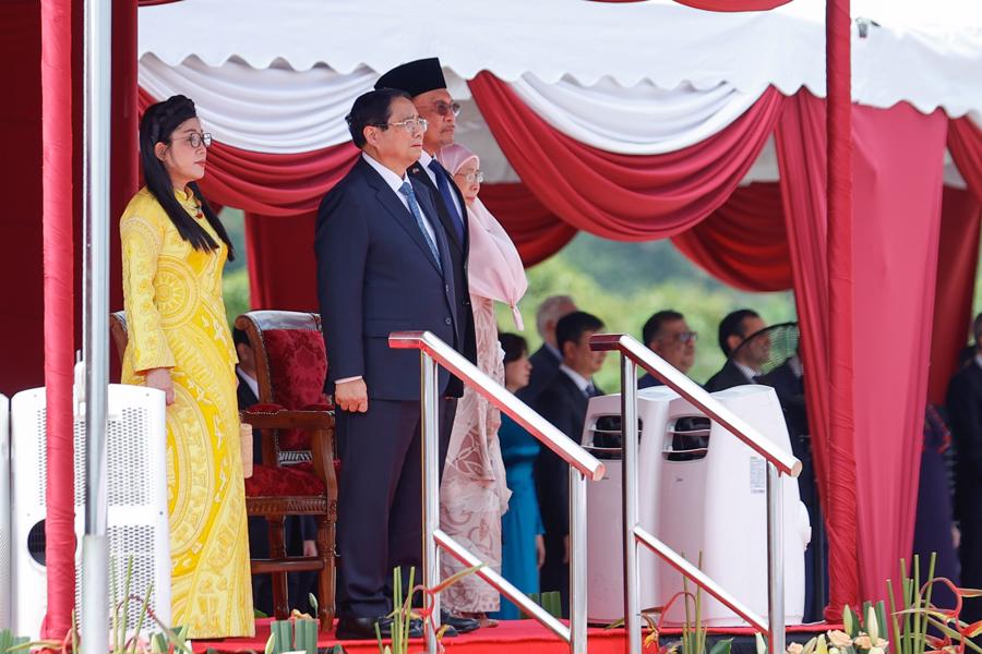 Thủ tướng Anwar Ibrahim và Phu nhân bắt tay chào mừng Thủ tướng Chính phủ và Phu nhân, sau đó cùng nhau di chuyển lên bục danh dự - Ảnh: VGP