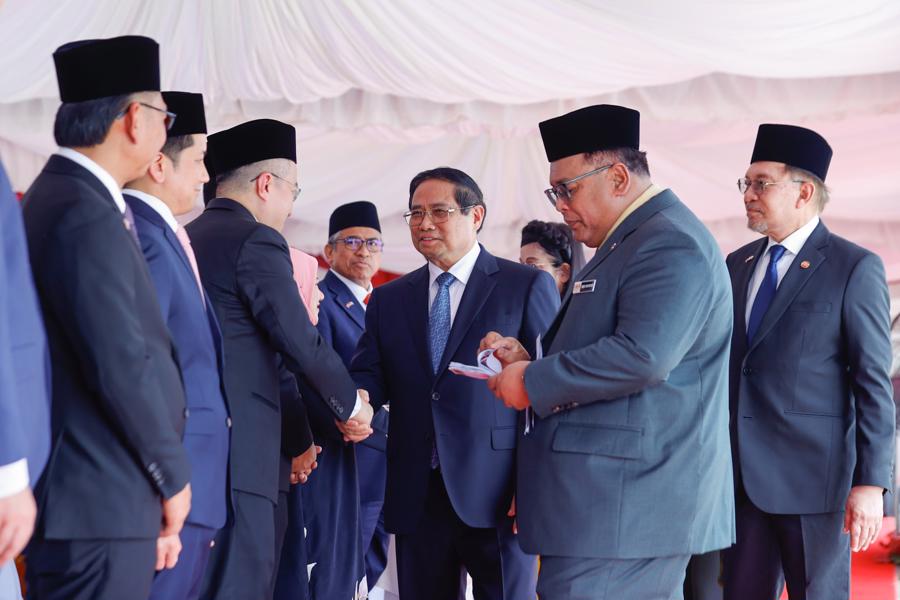 Thủ tướng Anwar Ibrahim và Phu nhân giới thiệu với Thủ tướng Phạm Minh Chính và Phu nhân về đoàn đại biểu Malaysia dự lễ đón - Ảnh: VGP