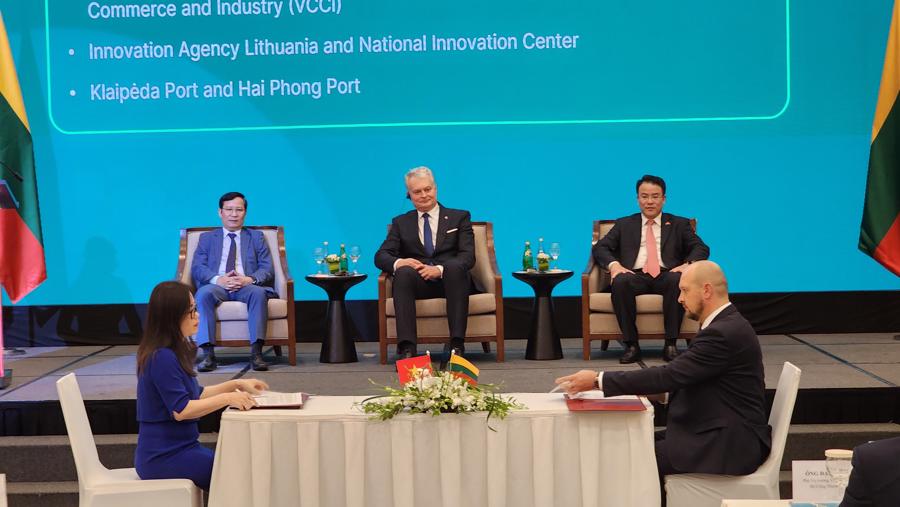 Lithuanian President Gitanas Nauséda (middle), VCCI Chairman Pham Tan Cong (left) and Deputy Minister of Finance Tran Quoc Phuong (right) witness the signing of cooperation agreements between Vietnam and Lithuania. Photo: Viet An.