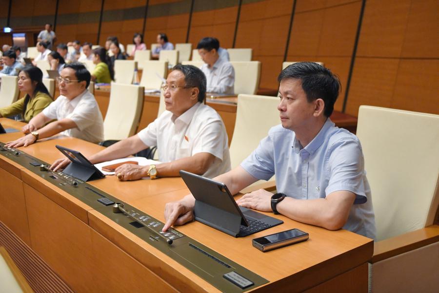 Các đại biểu Quốc hội bấm nút biểu quyết thông qua luật.