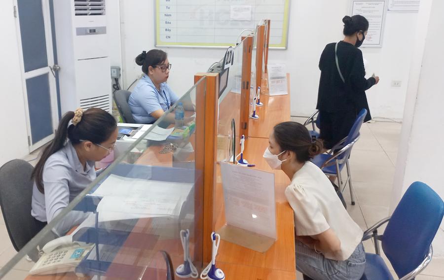 Công chức giải quyết thủ tục về bảo hiểm cho người lao động. Ảnh: TH.