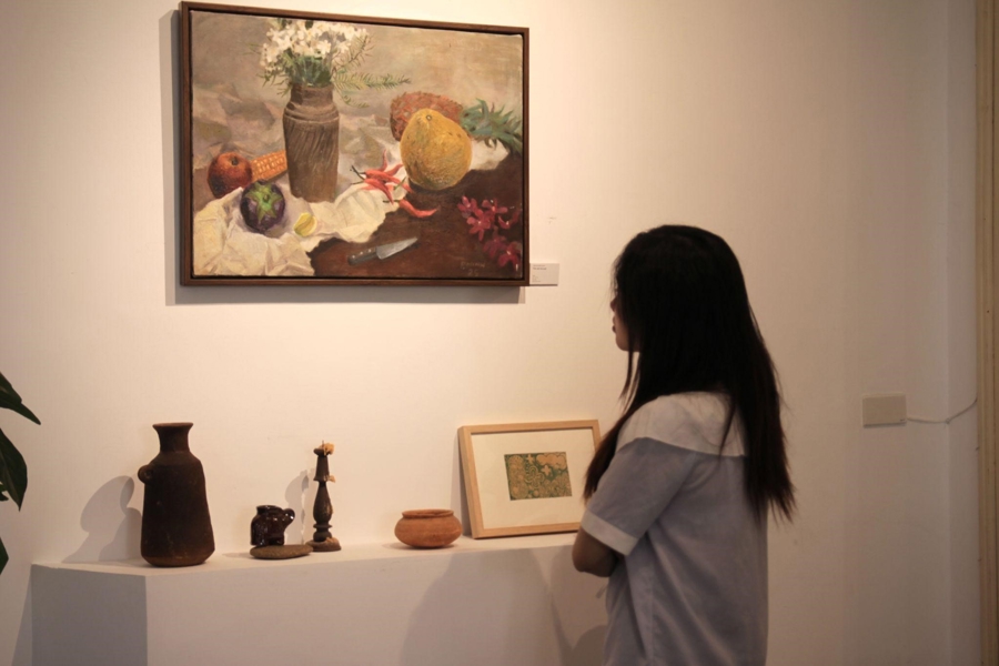 Một khách tham quan đang lặng ngắm tác phẩm trưng bày tại Nương Náu Art Hub – không gian kết nối nghệ sĩ trẻ với công chúng.