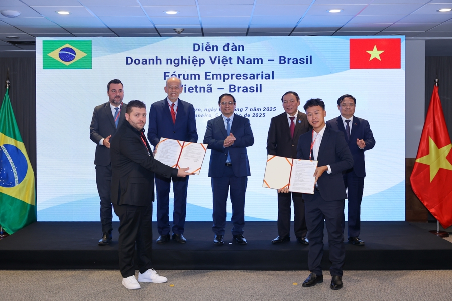 Thủ tướng Phạm Minh Chính và các đại biểu chứng kiến lễ trao thỏa thuận hợp tác giữa Công ty Cổ phần Nam Việt (NAVICO) và AV09 Comercio Exporter Ltda trong lĩnh vực thủy sản. Ảnh: VGP.
