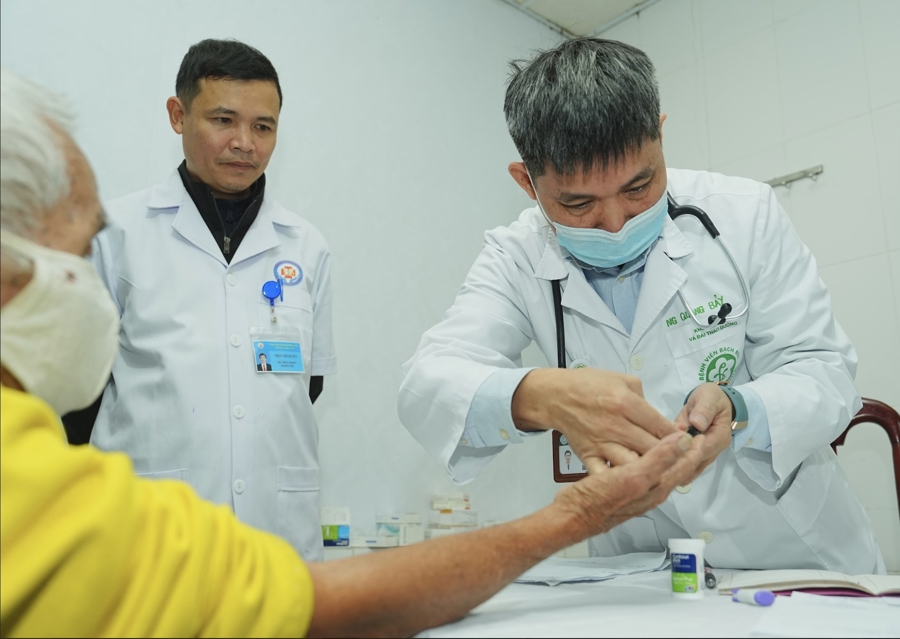 BS Nguyễn Quang Bảy thăm khám cho bệnh nhân. Ảnh: Hà Quyên.