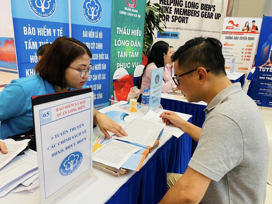 Người dân tìm hiểu thông tin về chính sách bảo hiểm xã hội, bảo hiểm y tế. Ảnh: Nhật Dương.