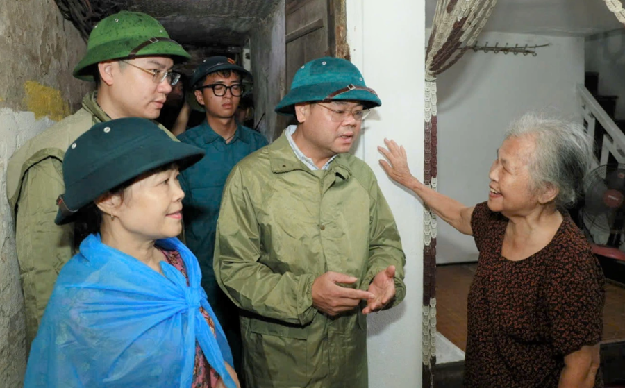 Ông Phạm Hồng Thái, Chủ tịch UBND phường Nam Định (thứ 2 bên phải), khảo sát, vận động người dân di chuyển đến nơi an toàn tránh bão. Ảnh: Thanh Bình