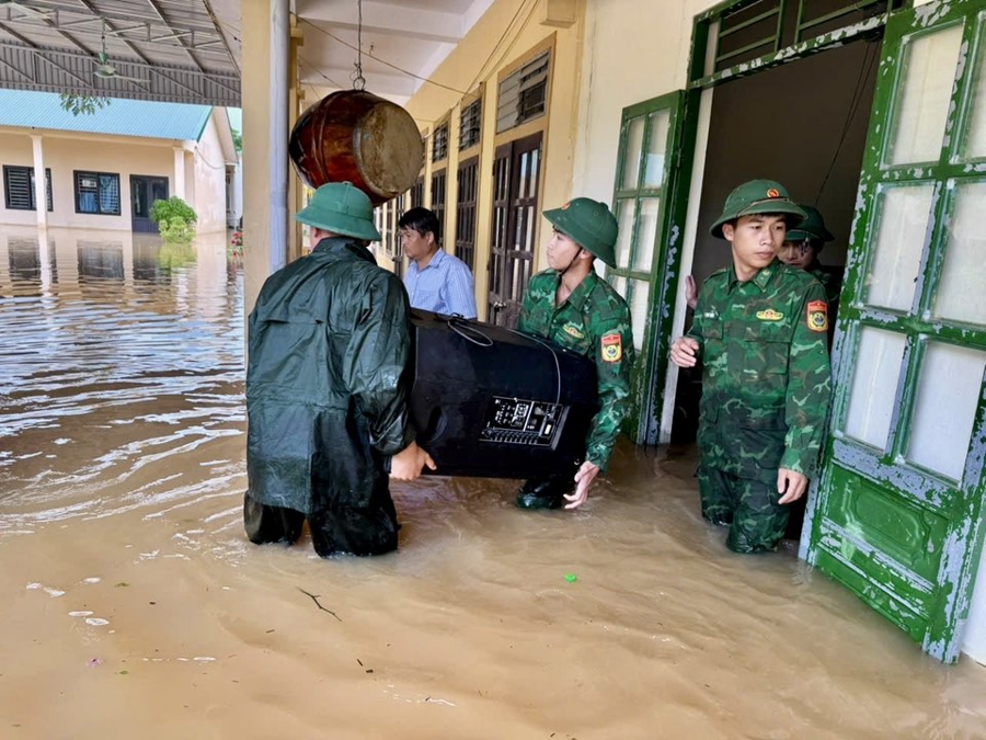 Các chiến sĩ biên phòng di chuyển các vật chất của Trường Tiểu học xã Thông Thụ ra khỏi khu vực bị ngập úng…